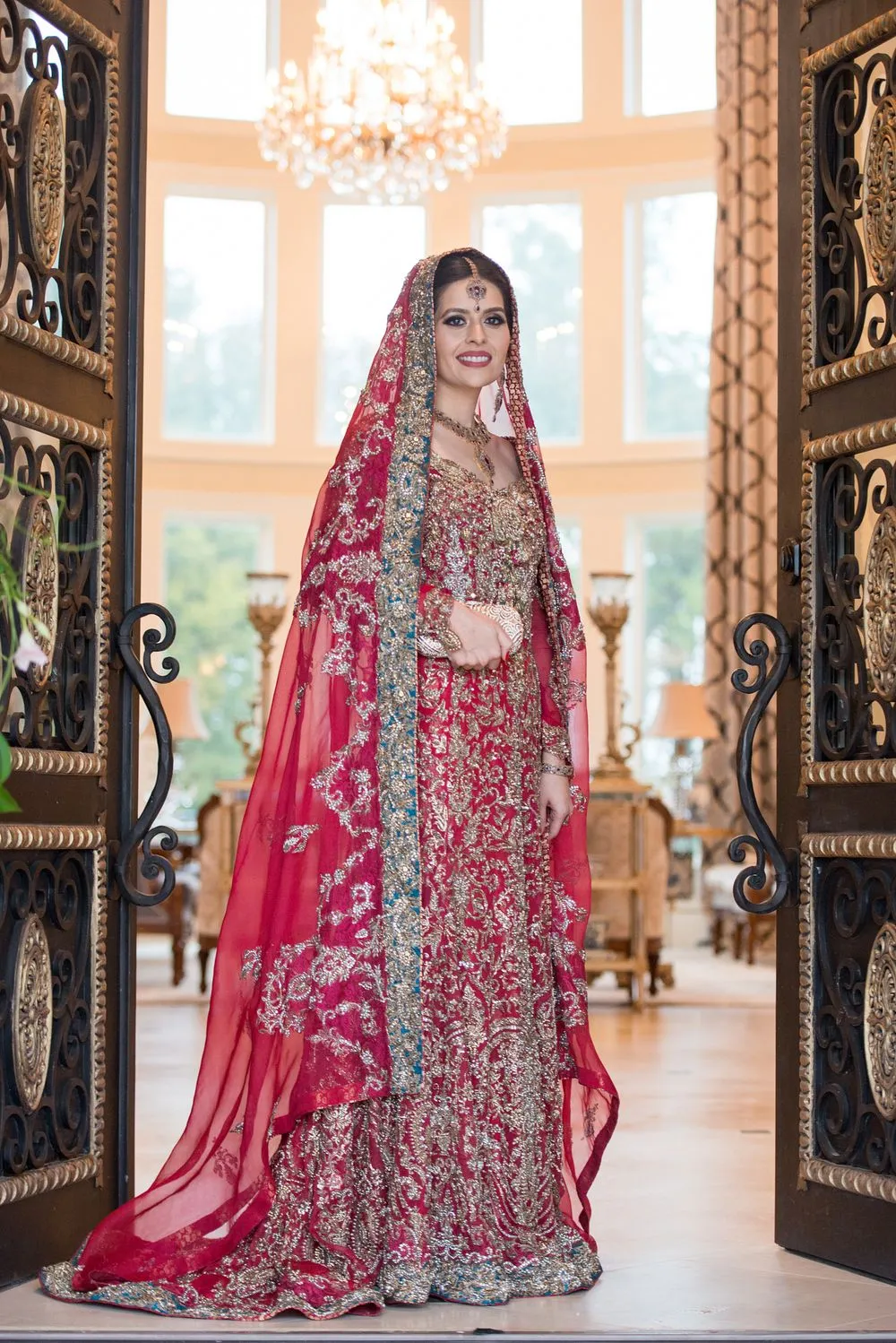 Bride in a red lehenga in a doorway